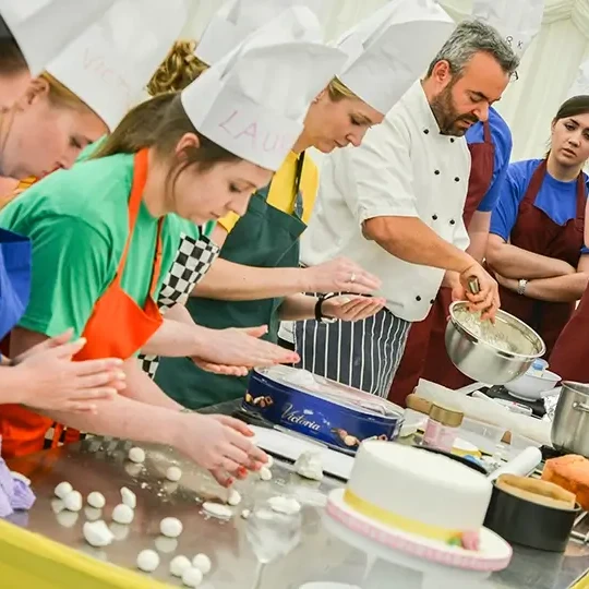 team building participants in baking challenge guided by pastry chef