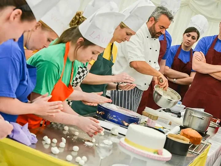 team building participants in baking challenge guided by pastry chef