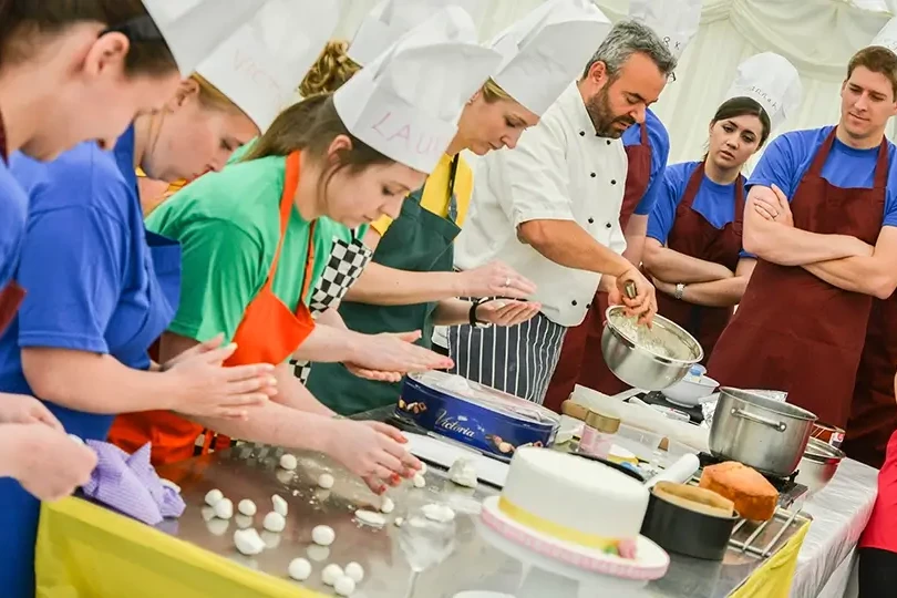team building participants in baking challenge guided by pastry chef