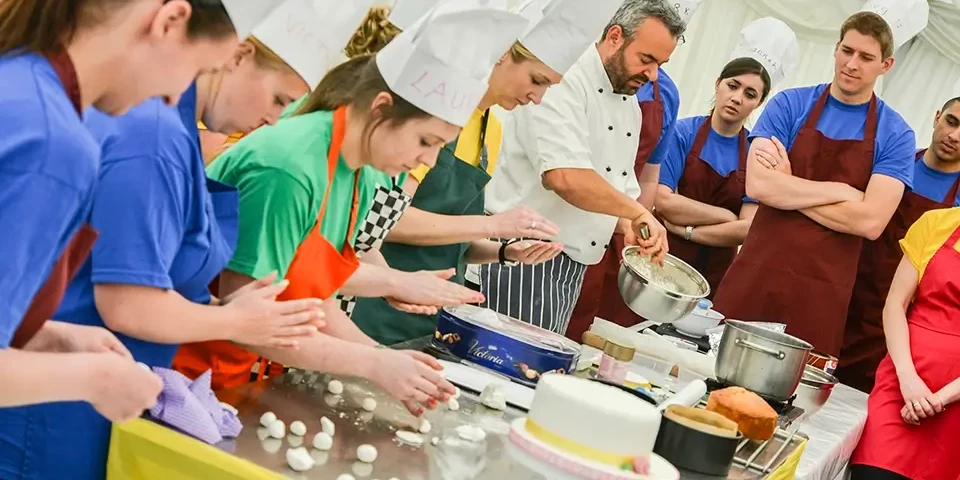 team building participants in baking challenge guided by pastry chef