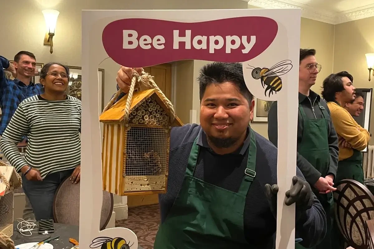 Bee Hotel team building participant taking a photo with Instagram frame