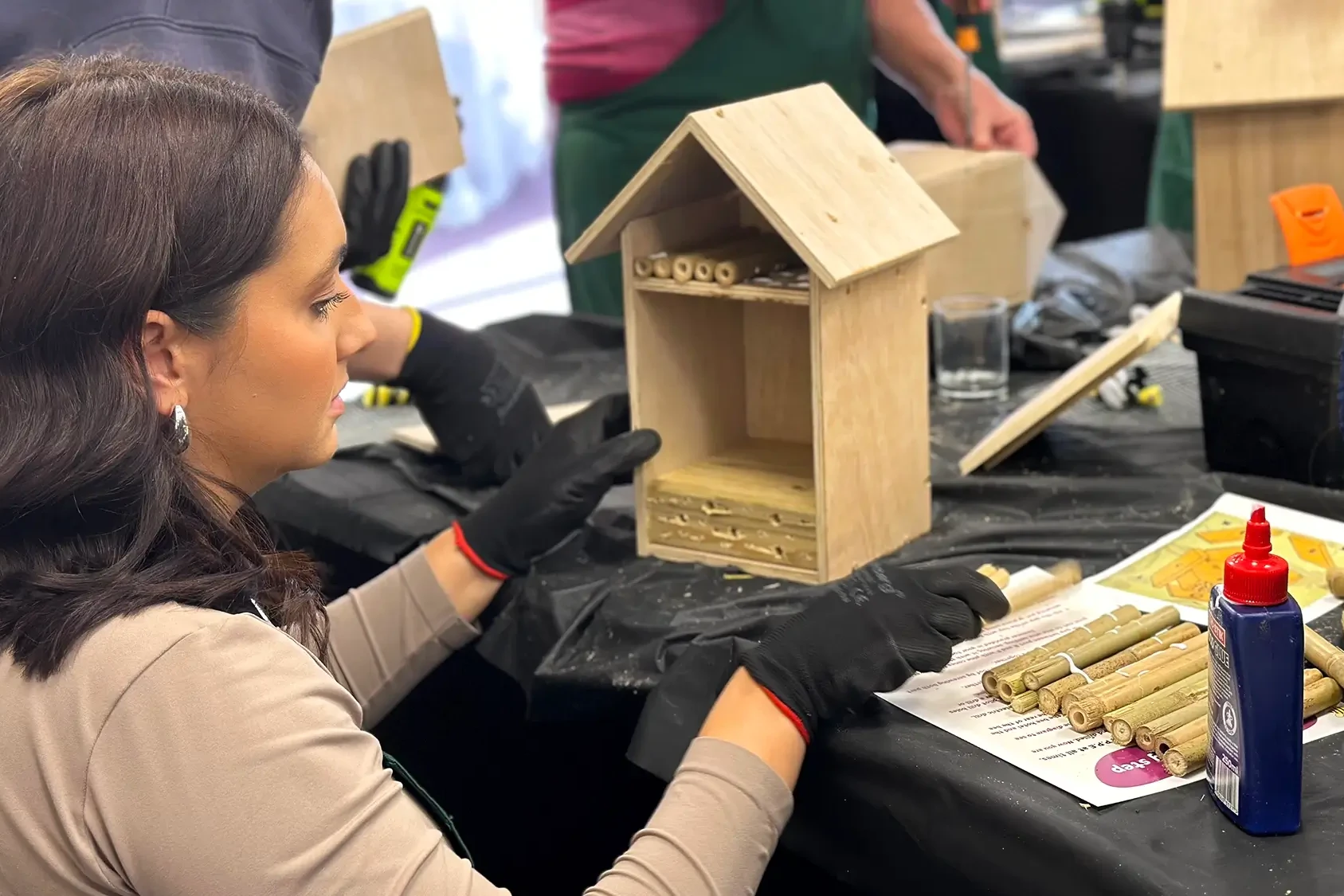 Bee hotel girl adding bamboo sticks to bee hotel