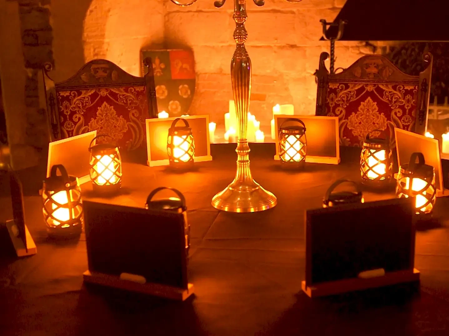 Traitors team building activity with slates and lanterns in a dark, castle room