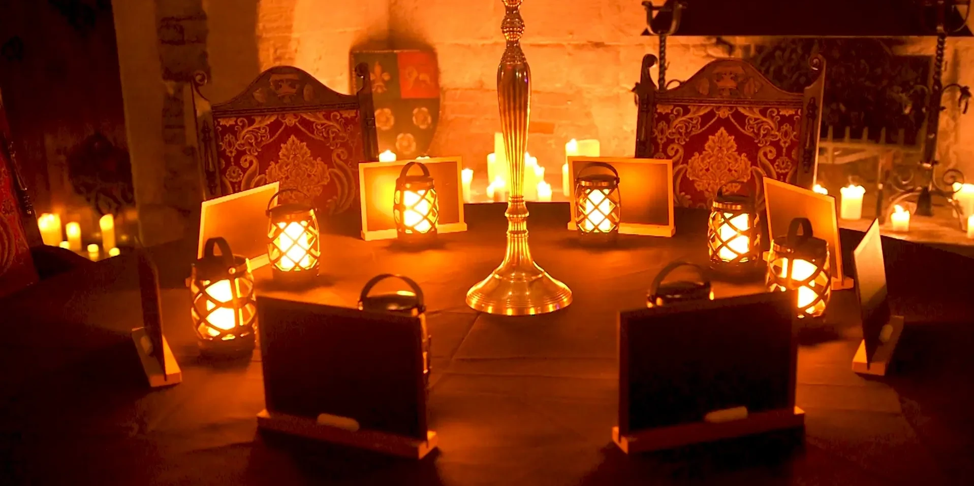 Traitors team building activity with slates and lanterns in a dark, castle room