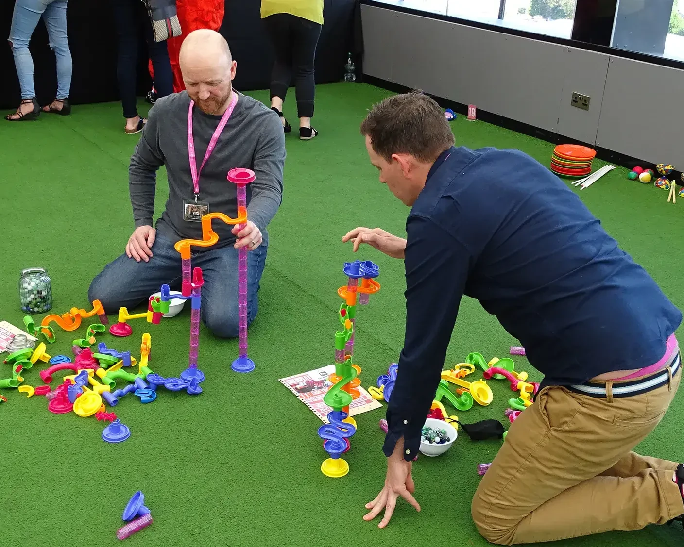 Team competing in indoor team building challenges with colourful loops and towers