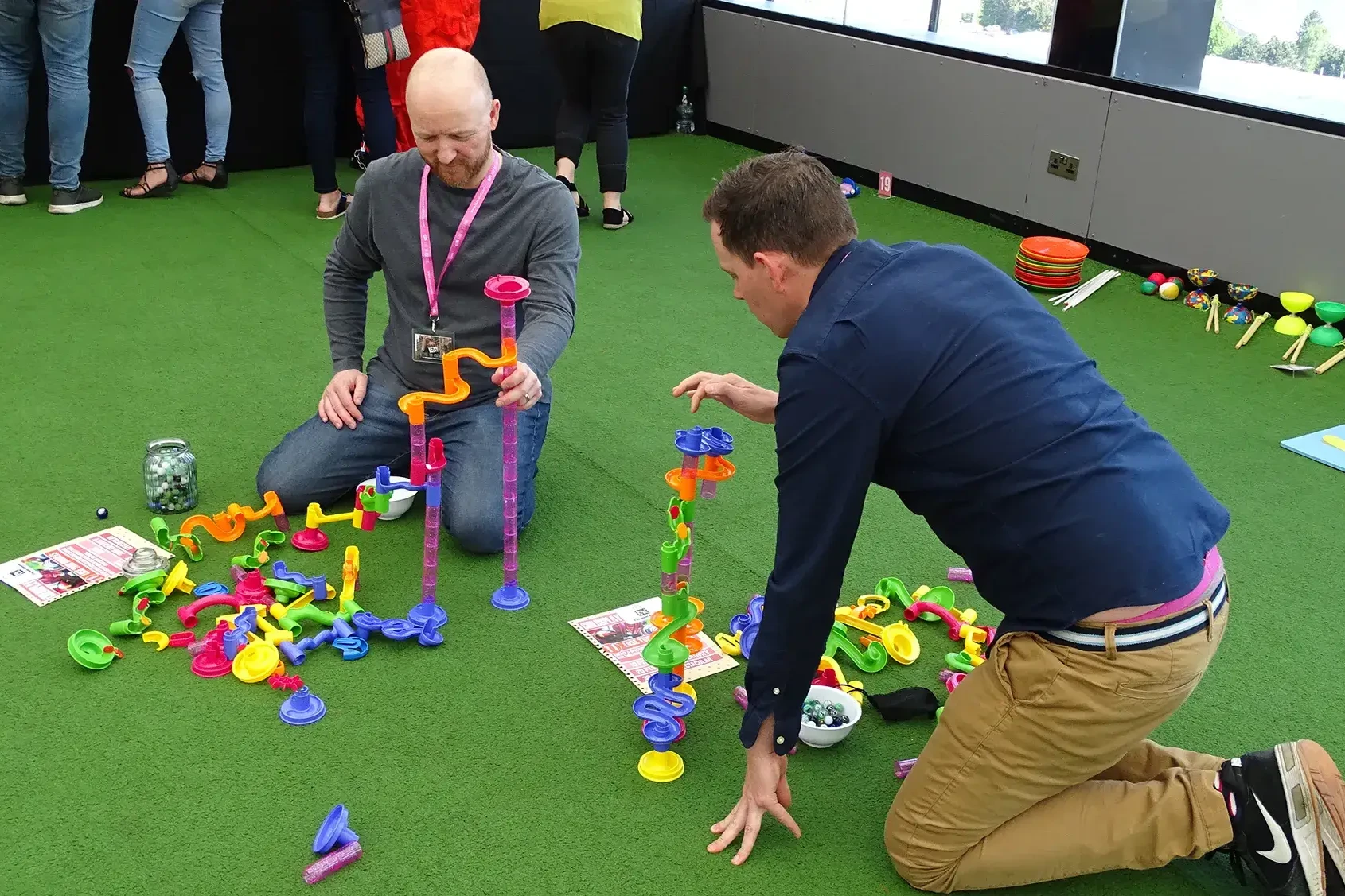 Team competing in indoor team building challenges with colourful loops and towers