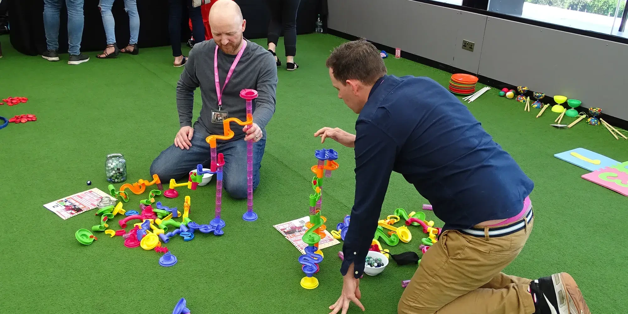 Team competing in indoor team building challenges with colourful loops and towers