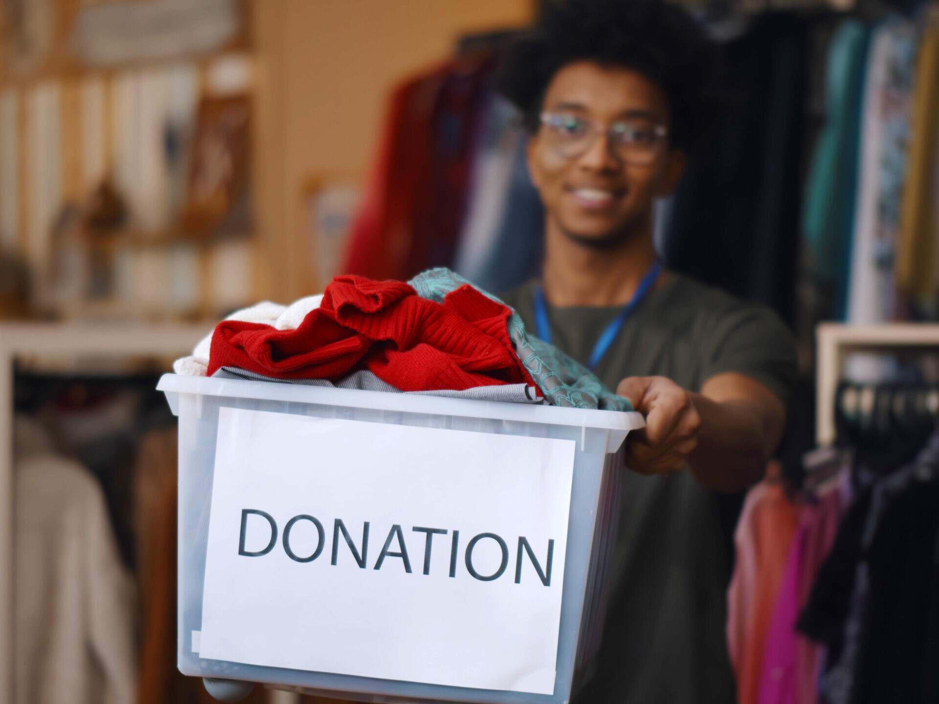 Man donating clothing in a box that says 