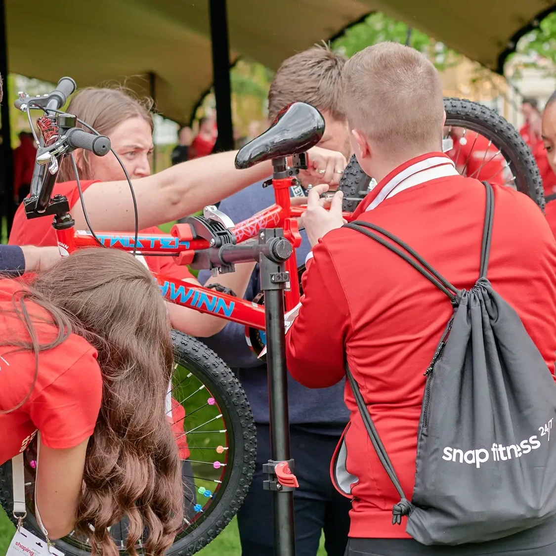 Team in red building a bike for charity