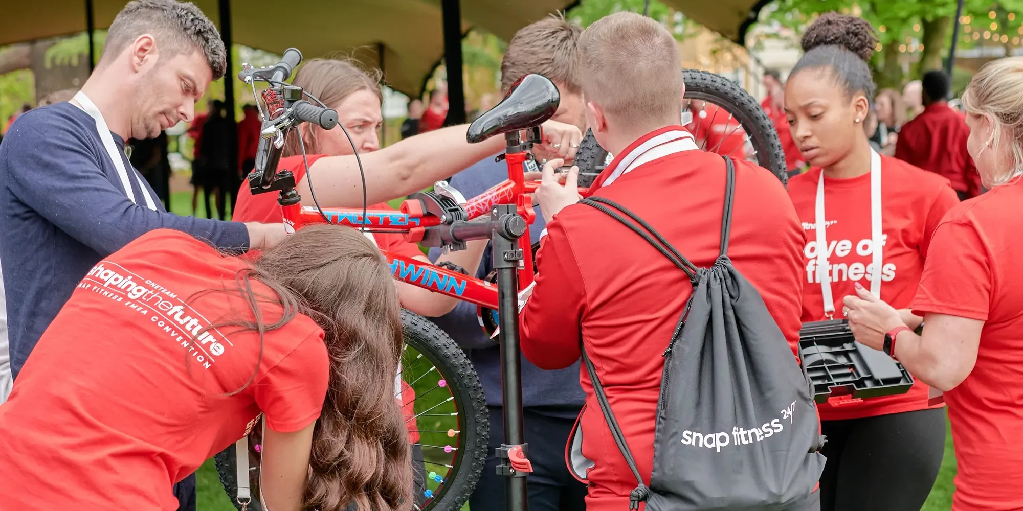 Team in red building a bike for charity