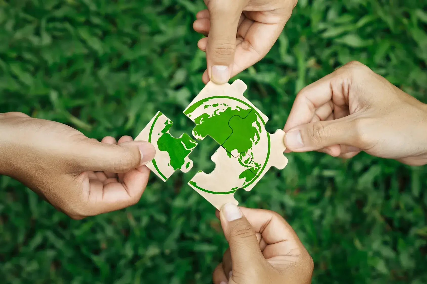 Hand of employees holding Earth puzzle in awareness of Earth Day activities at work