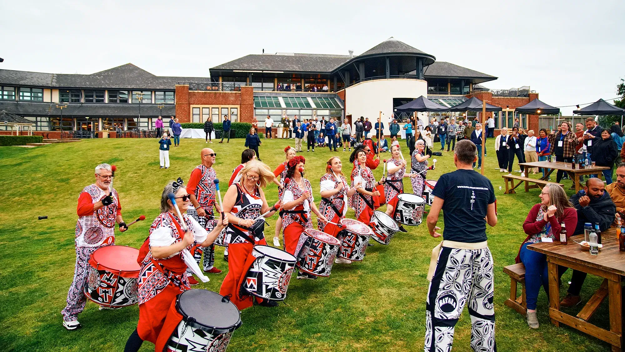 group of people in costumes playing drums at corporate summer event