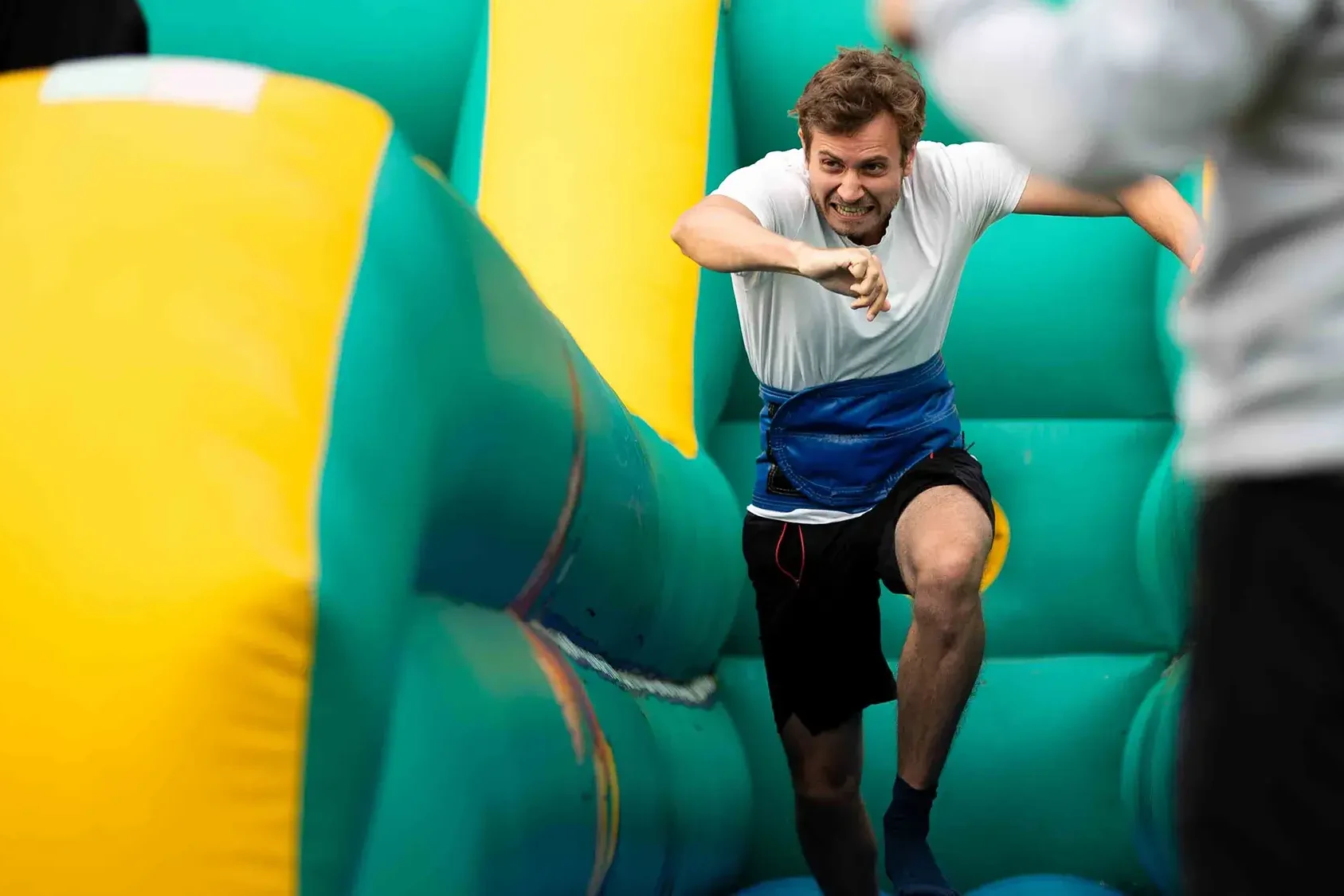 Team building participants running on colourful inflatable outdoors