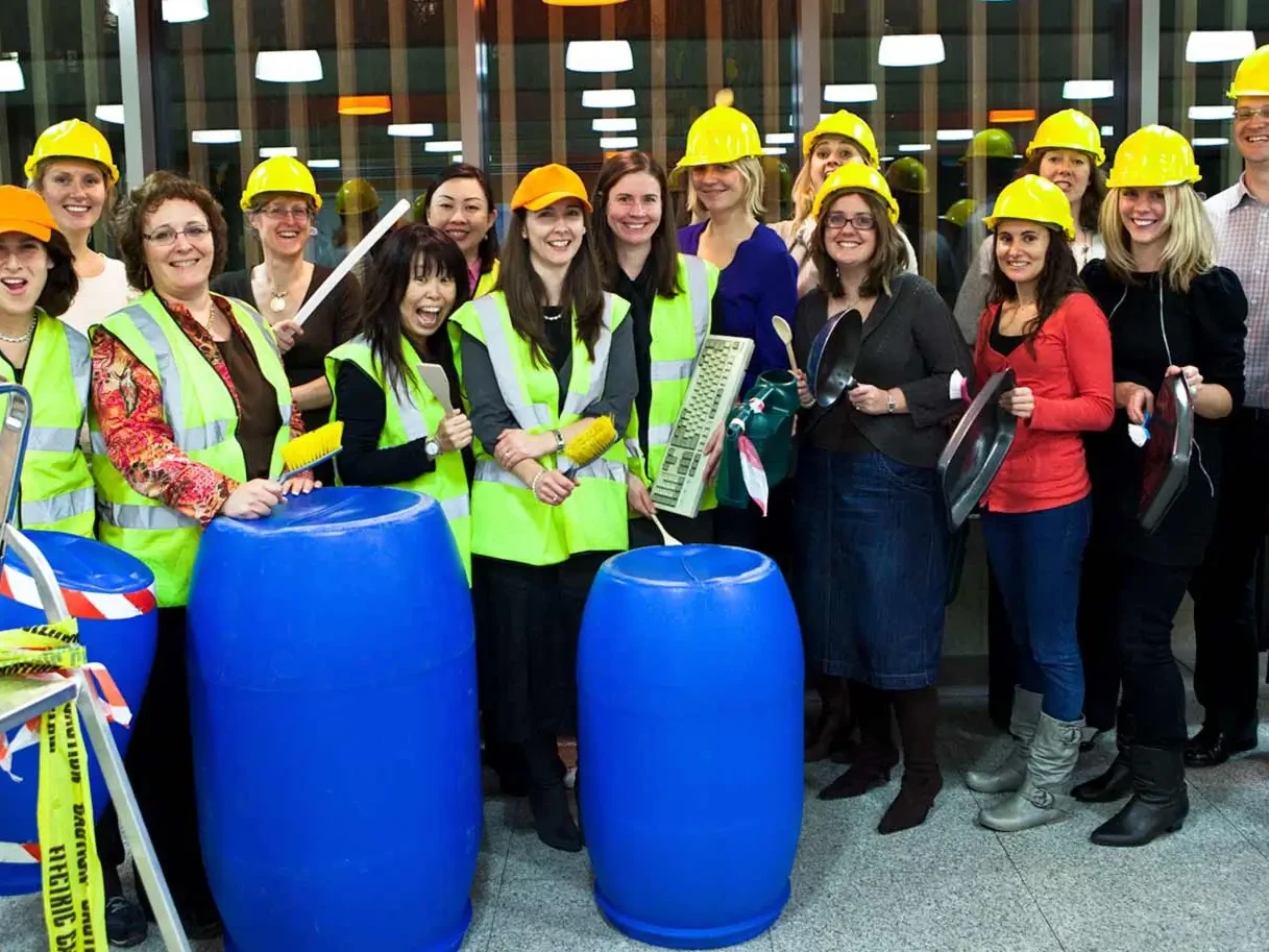 Group of team building participants in holding various objects for Junk Funk activity