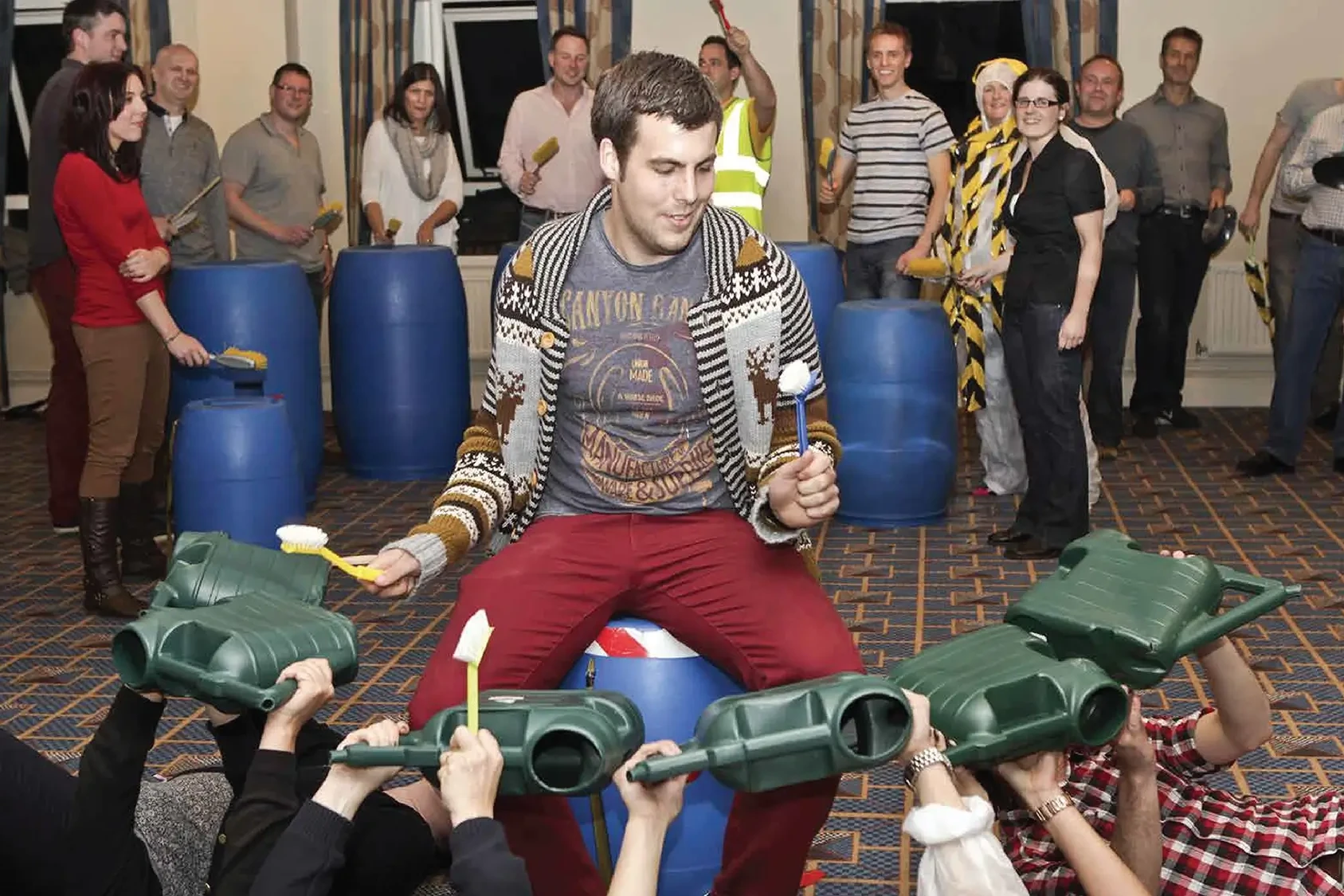 Junk Funk team building activity with participant drumming on green watering cans