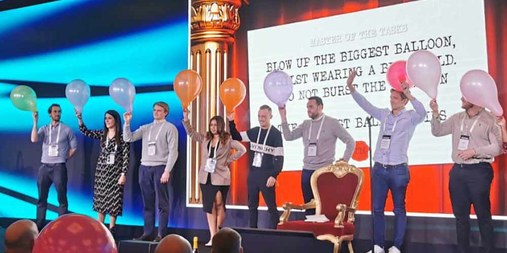 Colleagues stood on a stage with balloons in their hands