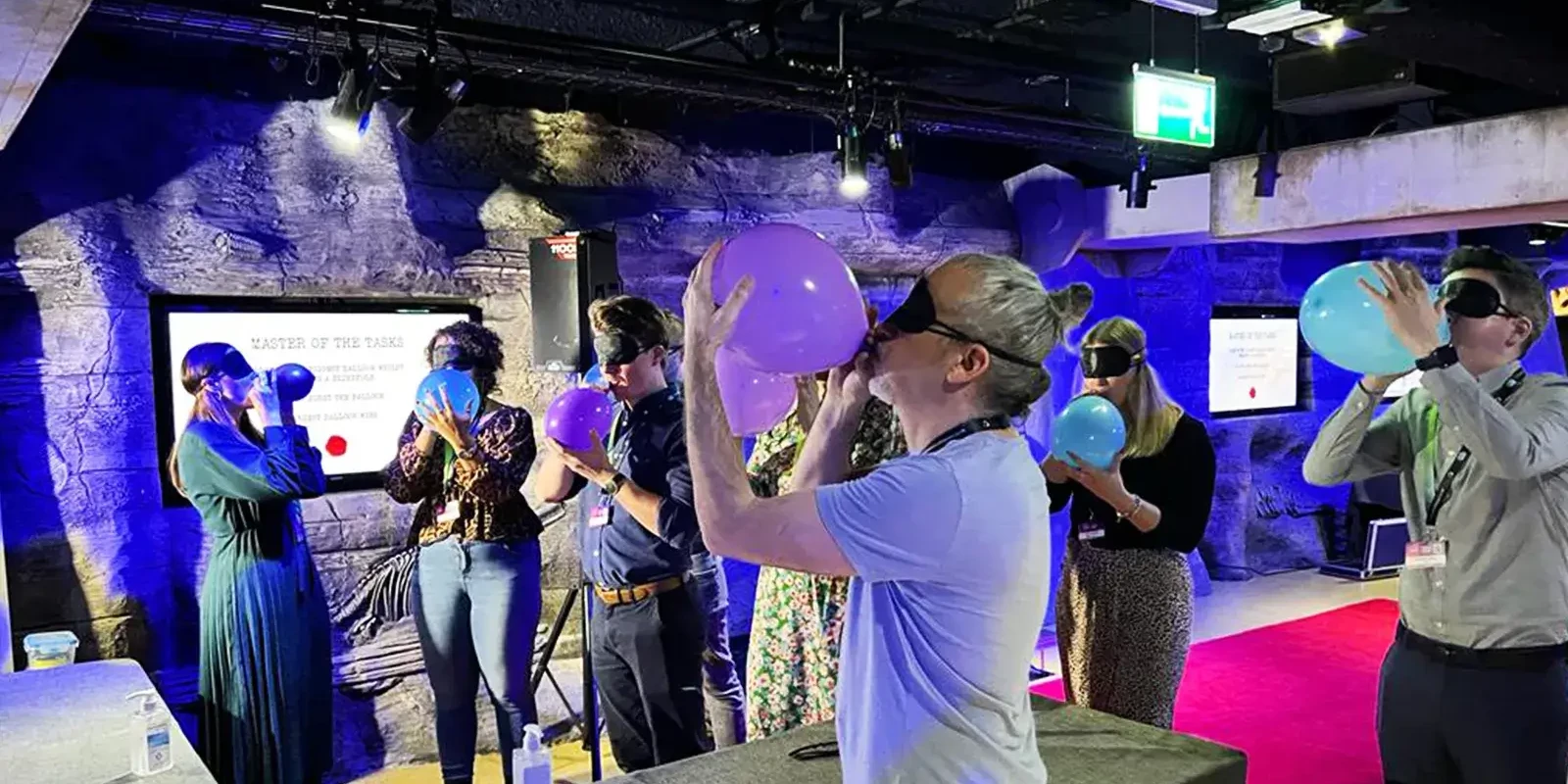 people blowing up balloons in master of the tasks team building game