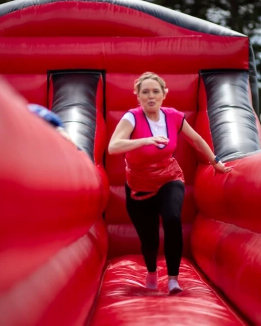Women running on red inflatable assault course in Olympic Sports Day