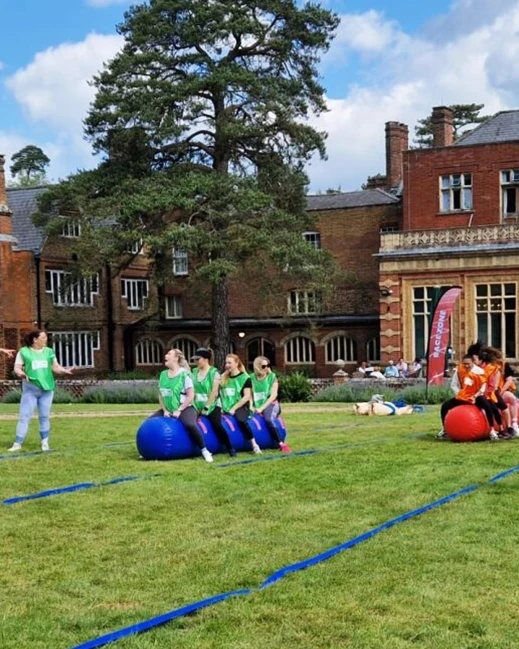 Teams racing in outdoor team building event on inflatable caterpillars