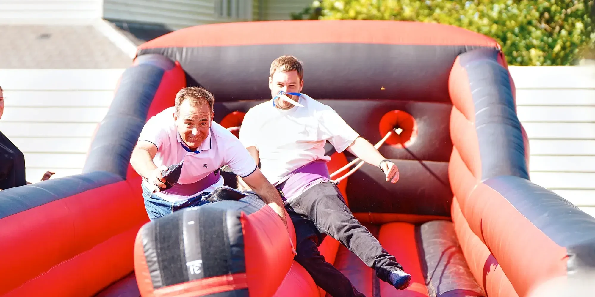 Team building participants competing on inflatable course