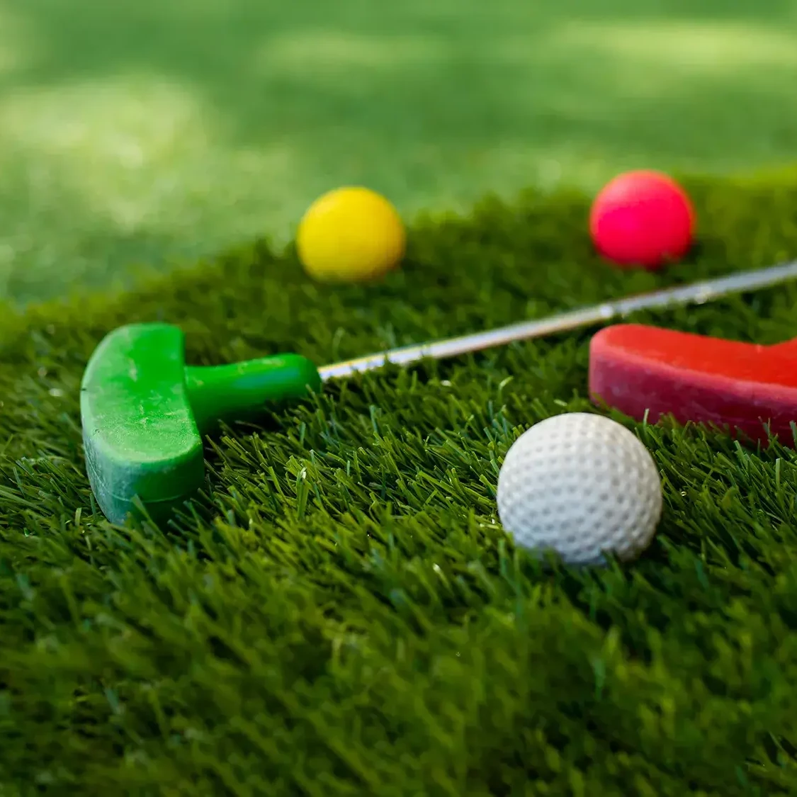Colourful mini golf putter and golf balls for charity team building event