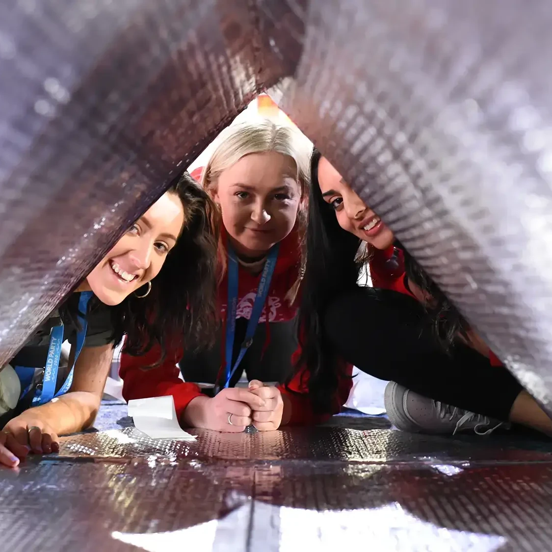 Charity team building participants inside sleep pod smiling