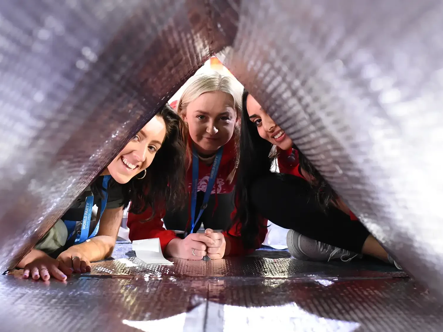 Charity team building participants inside sleep pod smiling