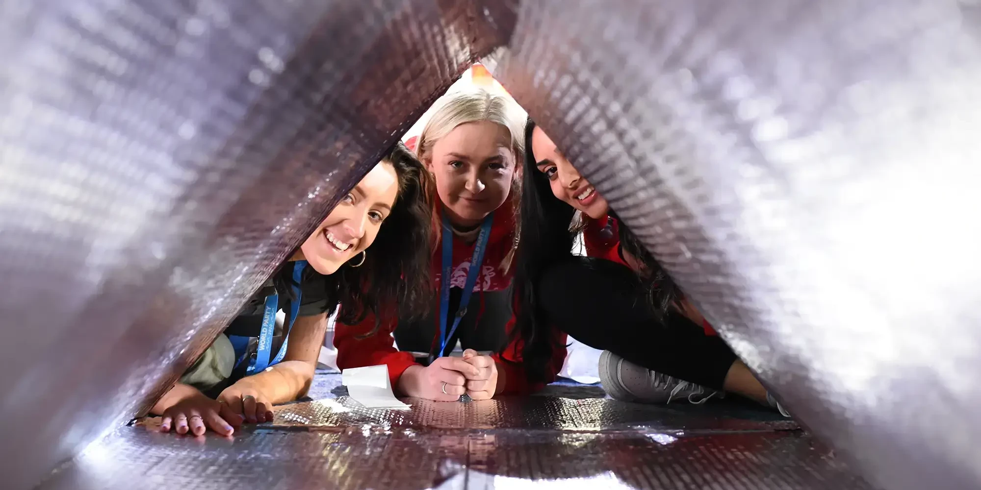 Charity team building participants inside sleep pod smiling