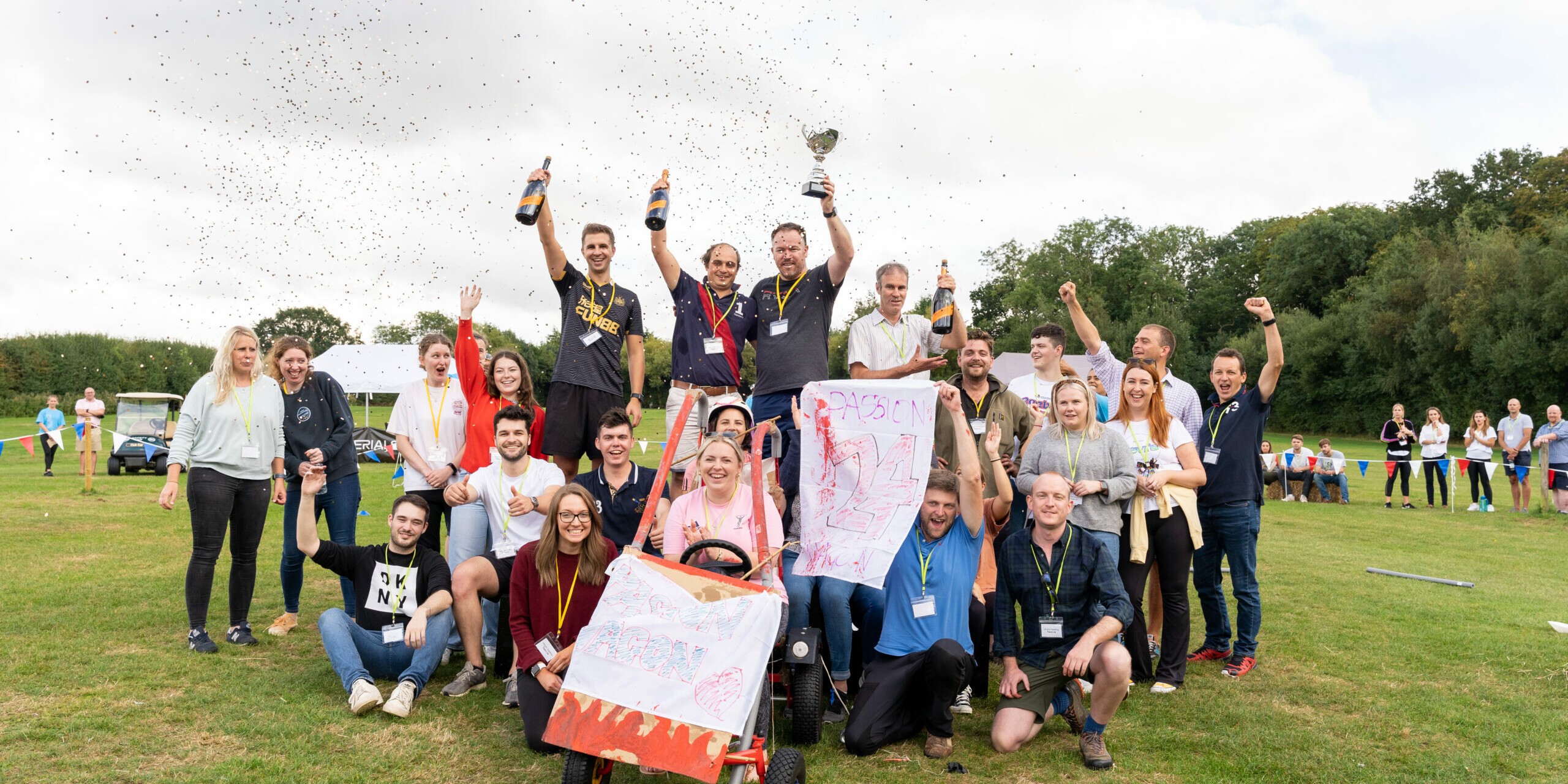 team of employees holding up trophy and medal after winning Soap Box Derby team building event