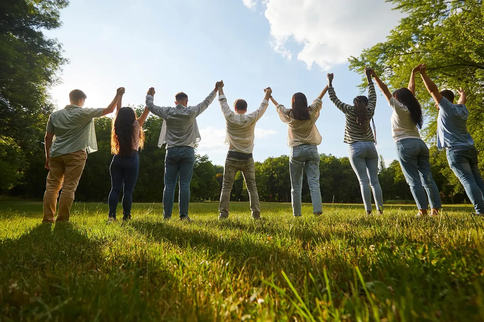 Team holding hands looking at the sky in spring team building activity