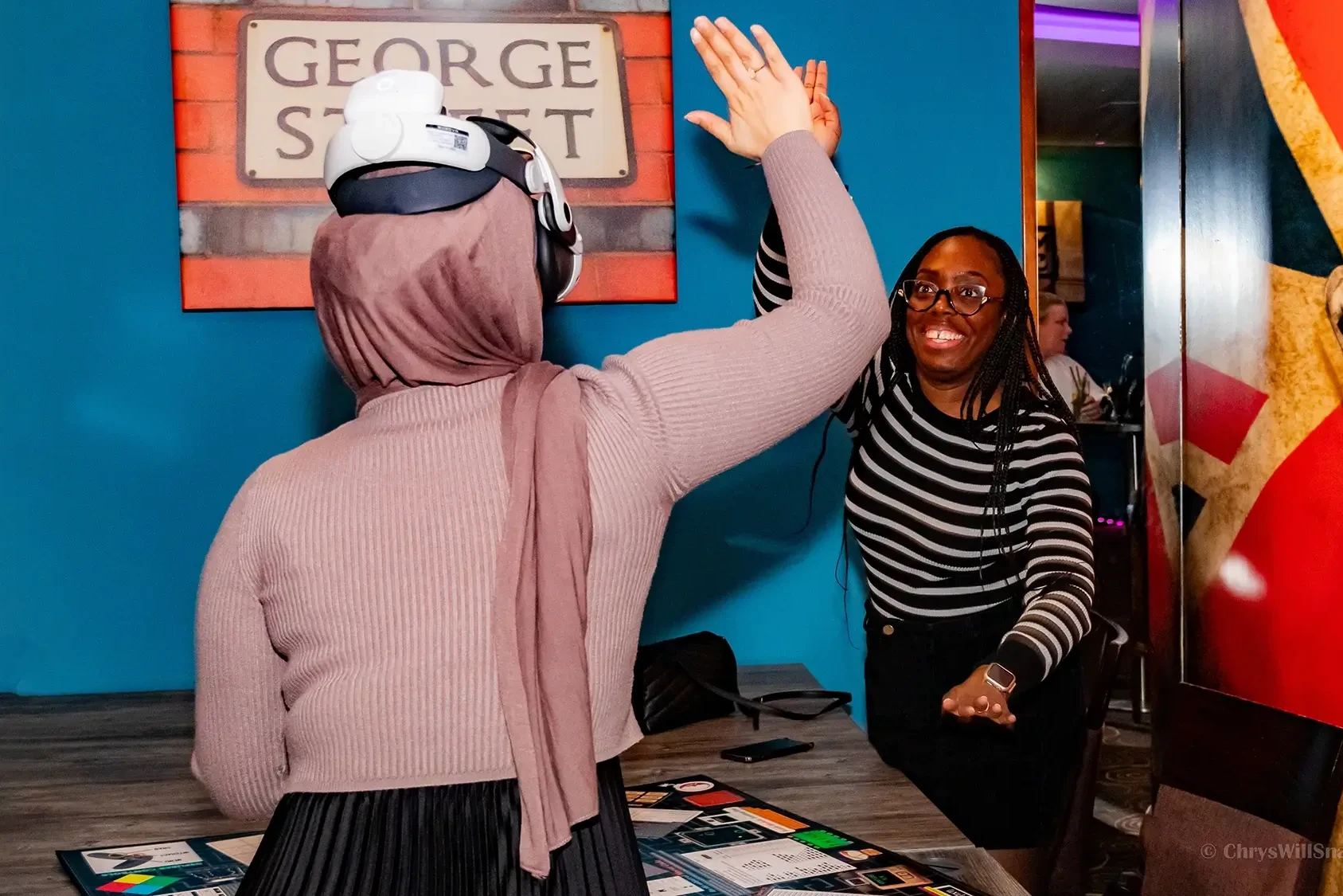 team high fiving after VR team building game