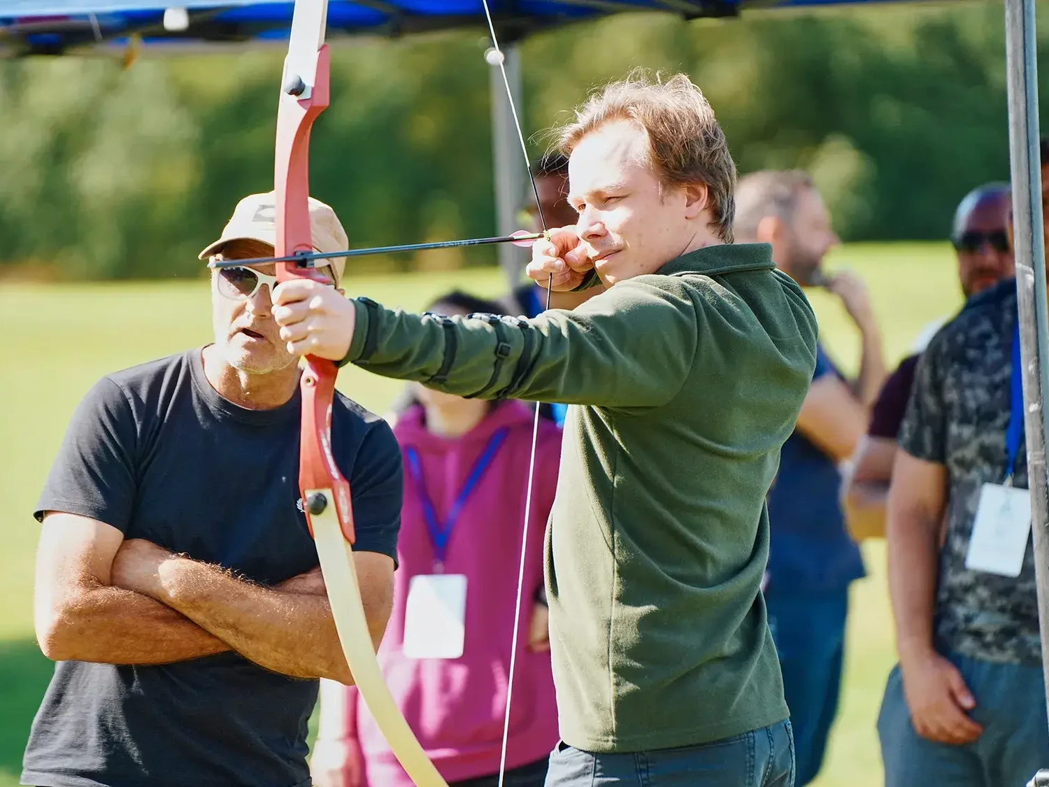 team building participant aiming for target in outdoor archery event