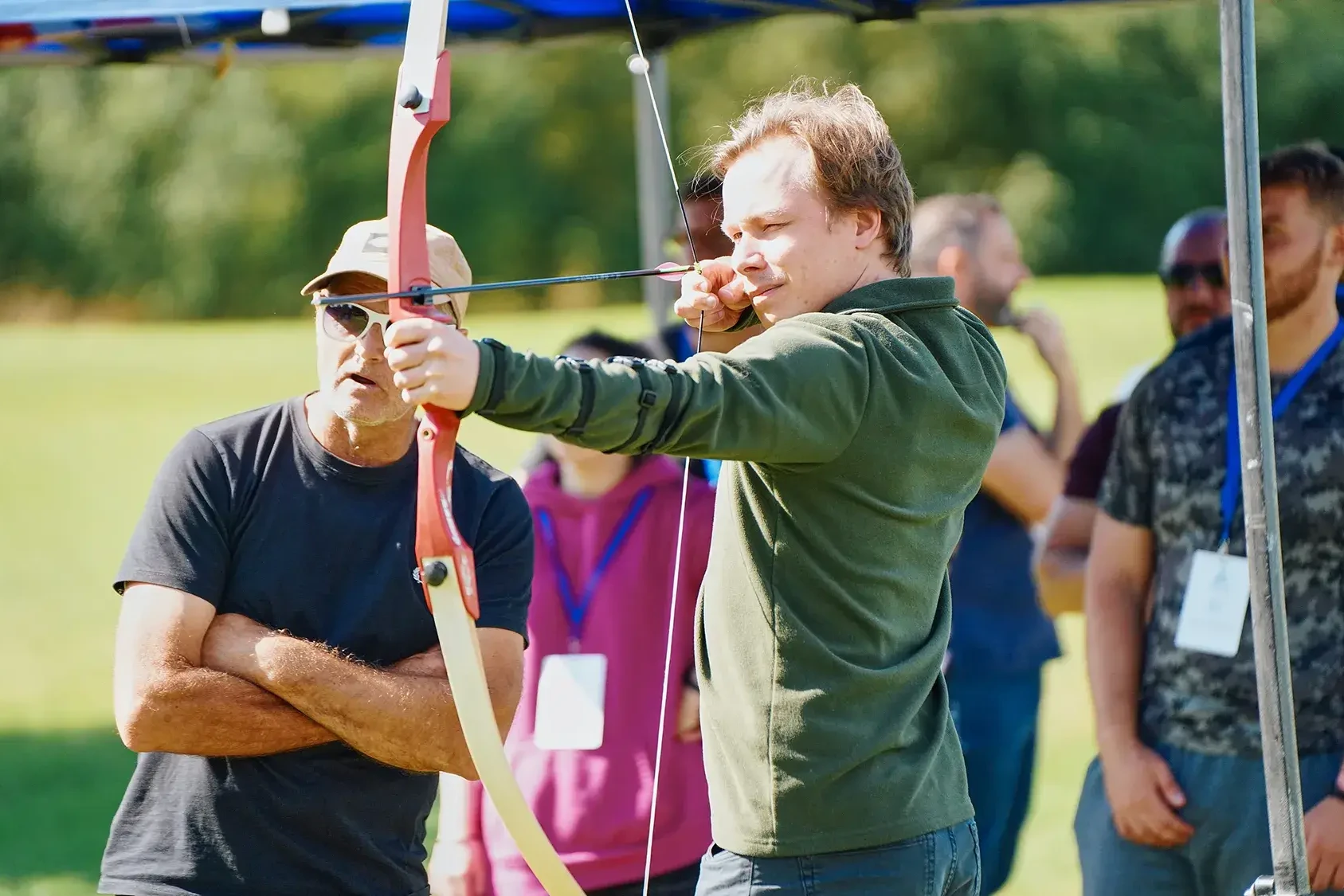 team building participant aiming for target in outdoor archery event