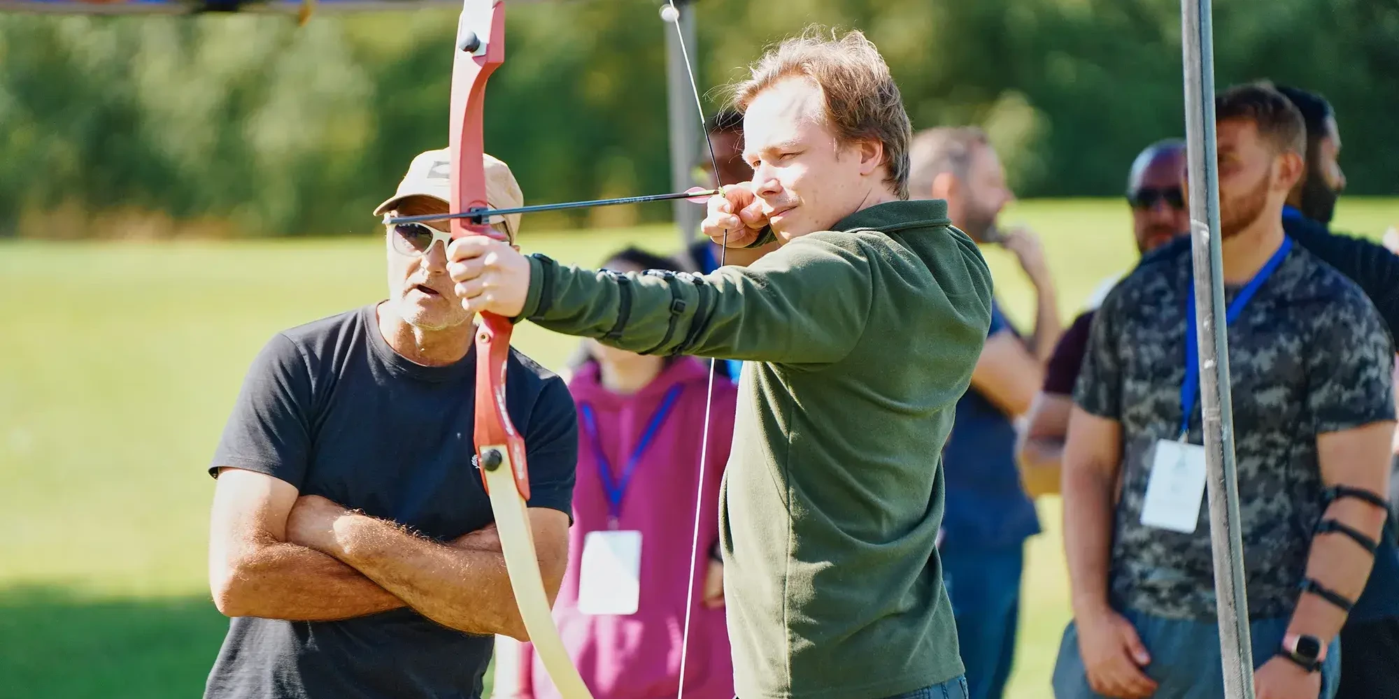 team building participant aiming for target in outdoor archery event