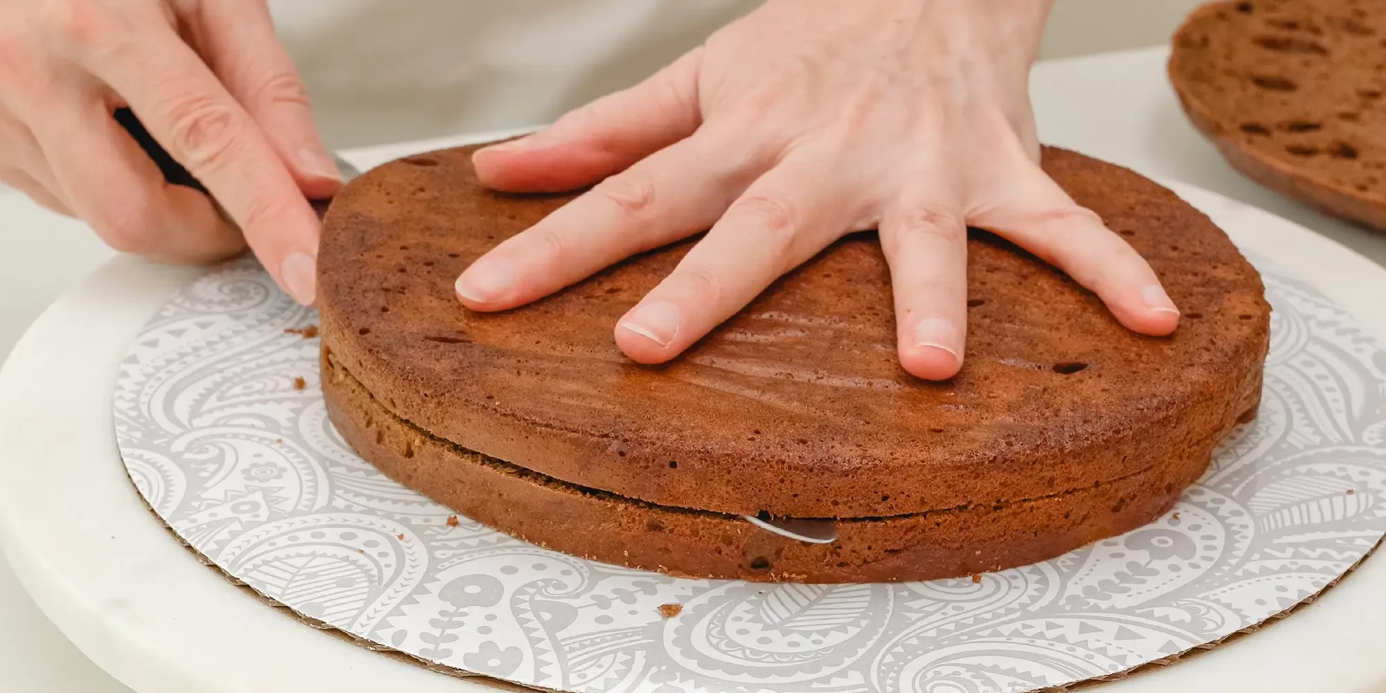 slicing cake base in baking team building activity