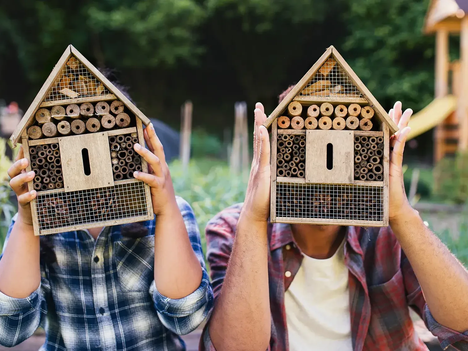 two people holding bee hotels in team building workshop