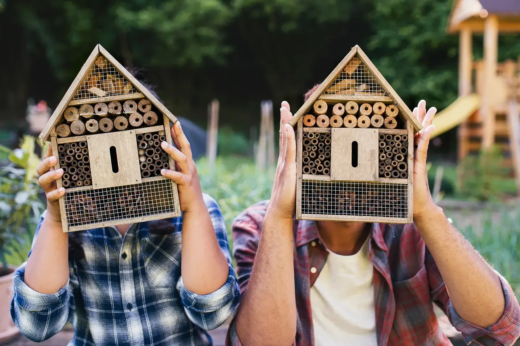 two people holding bee hotels in team building workshop
