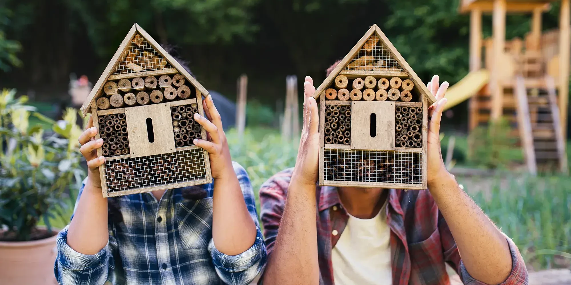 two people holding bee hotels in team building workshop