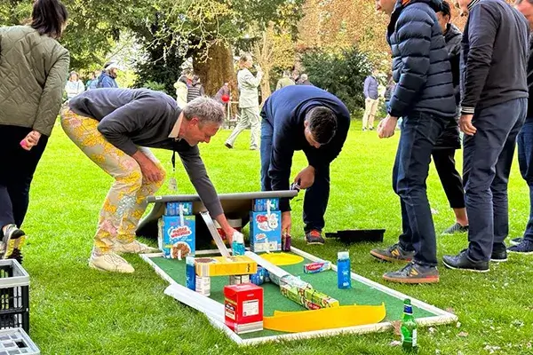 people building mini gold hole with cereal boxes in charity team building event
