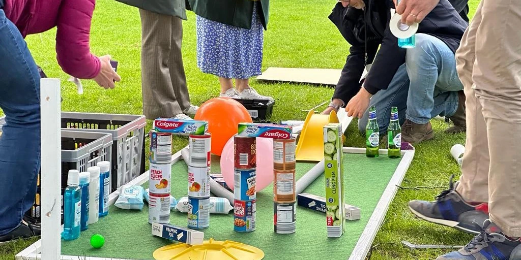 employees building mini golf holes for charity team building activity