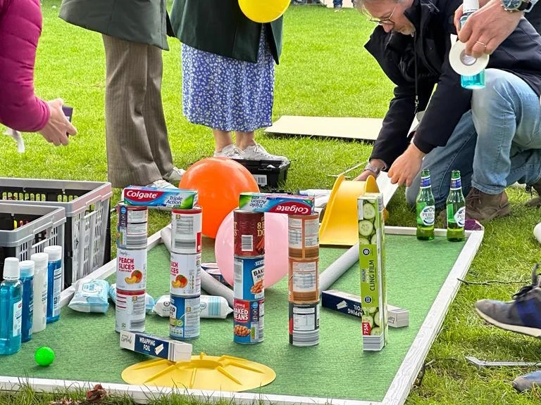 employees building mini golf holes for charity team building activity