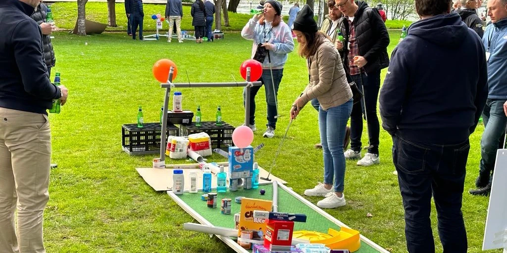 employees playing mini golf course after building the holes in charity team building