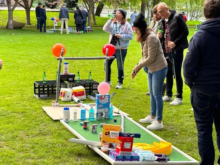 employees playing mini golf course after building the holes in charity team building