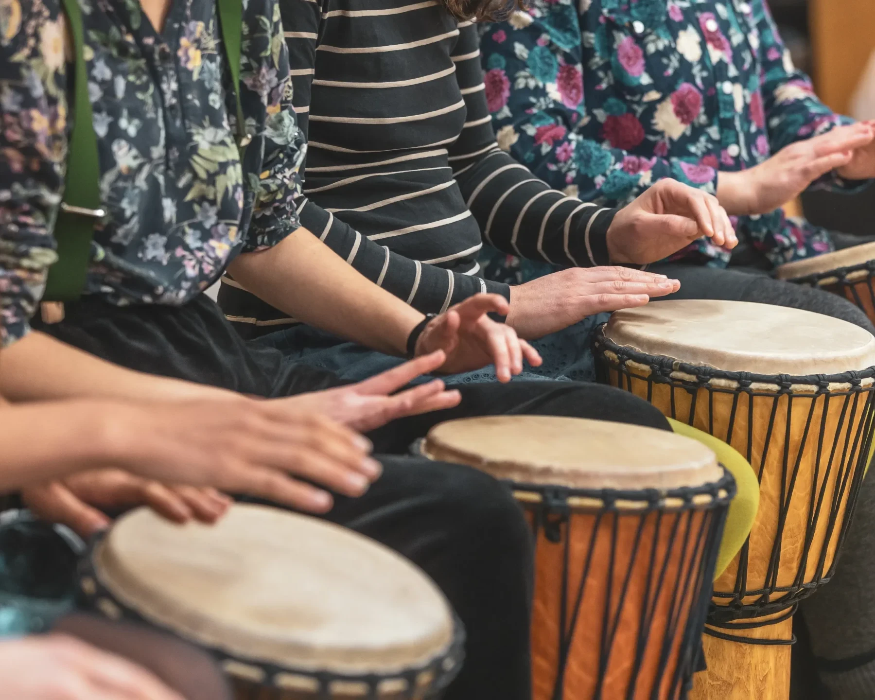 close-up of team building participants drumming