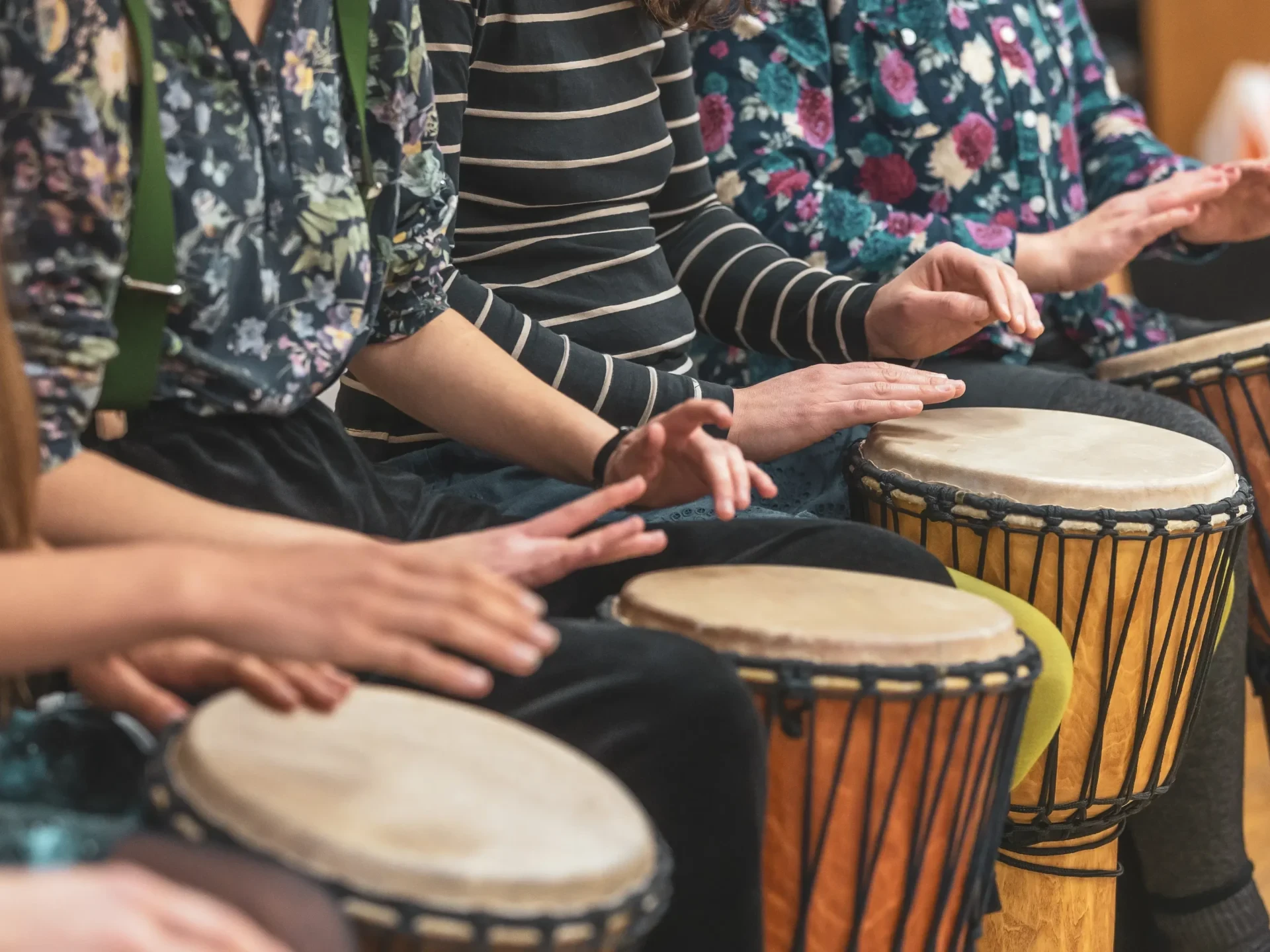 close-up of team building participants drumming