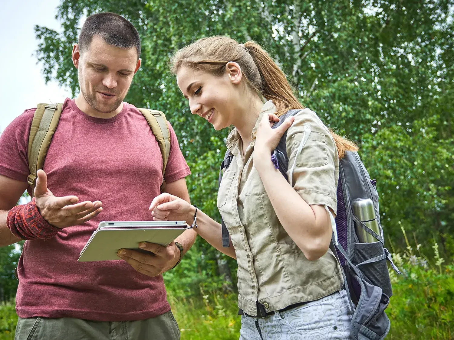 team of two people looking at iPad in GPS treasure hunt in the countryside