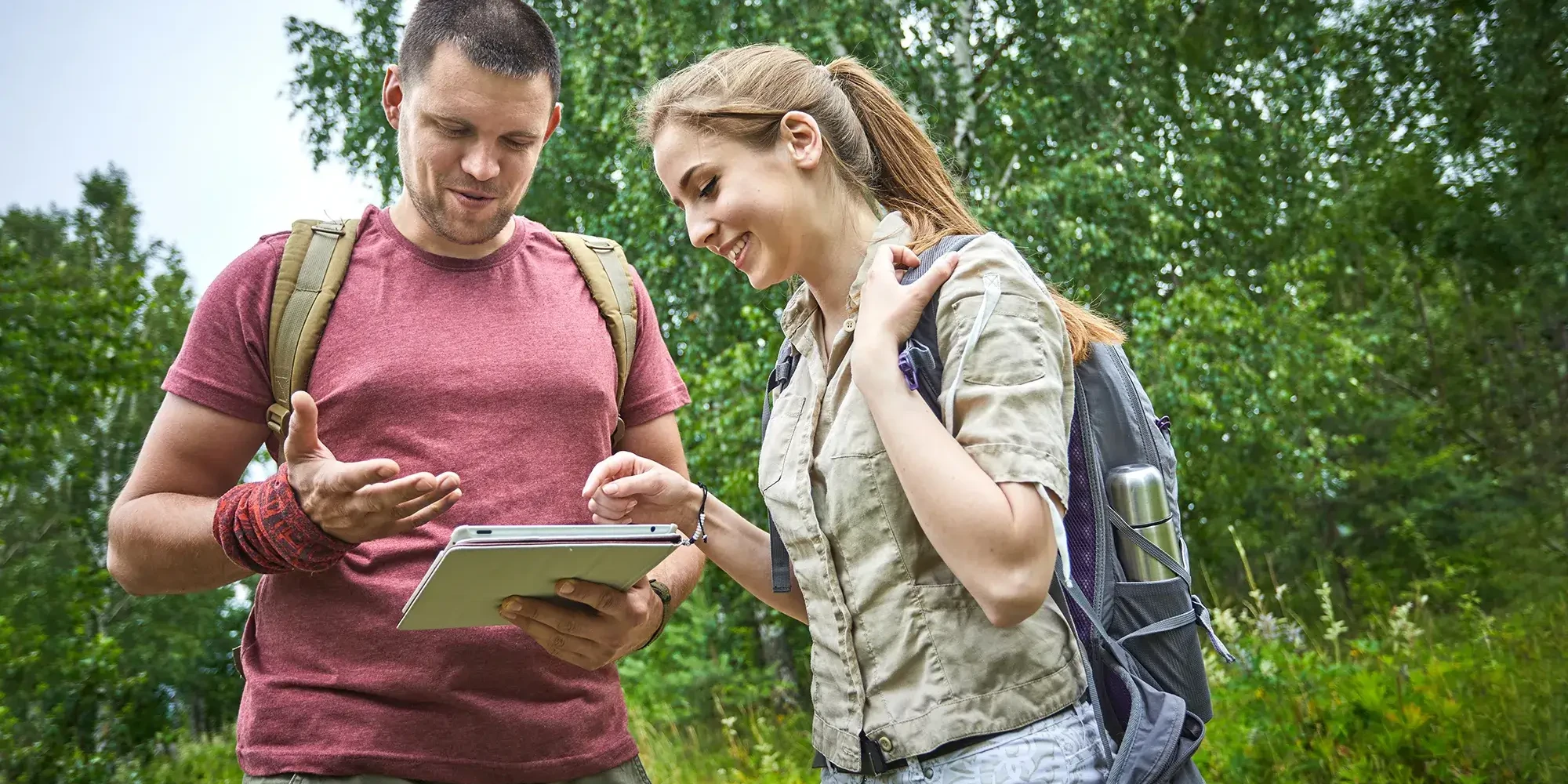 team of two people looking at iPad in GPS treasure hunt in the countryside