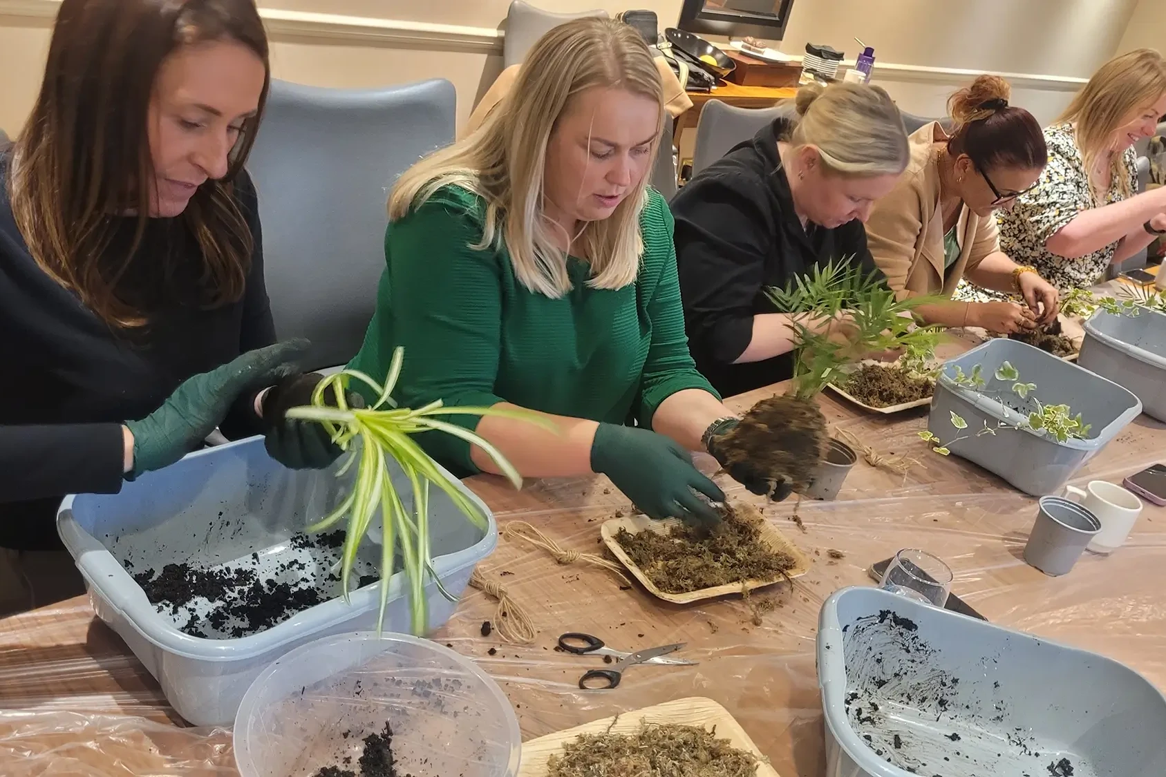 Women creting kokedama art in team building activity