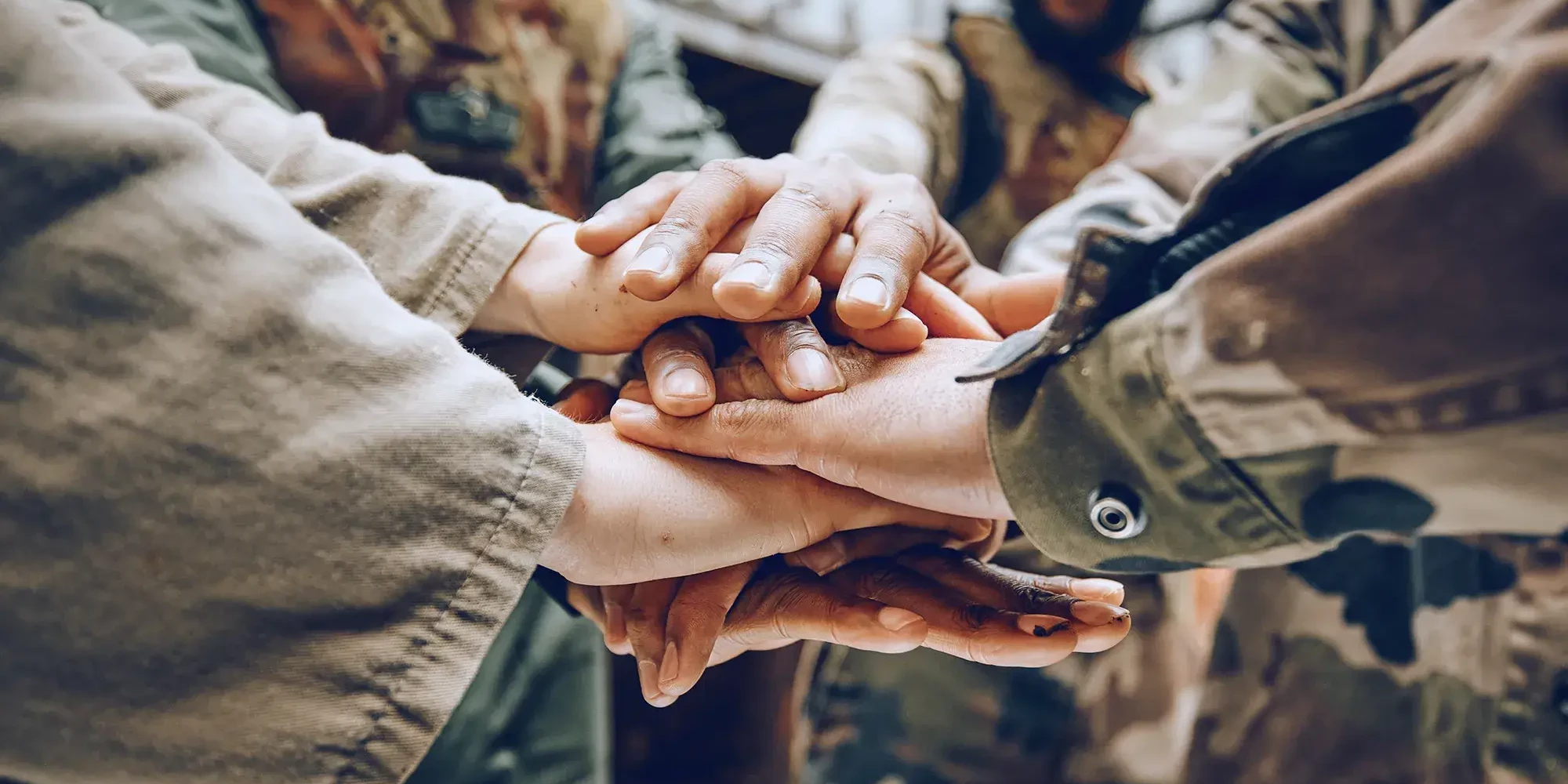 People in army uniforms holding hands in team building activity