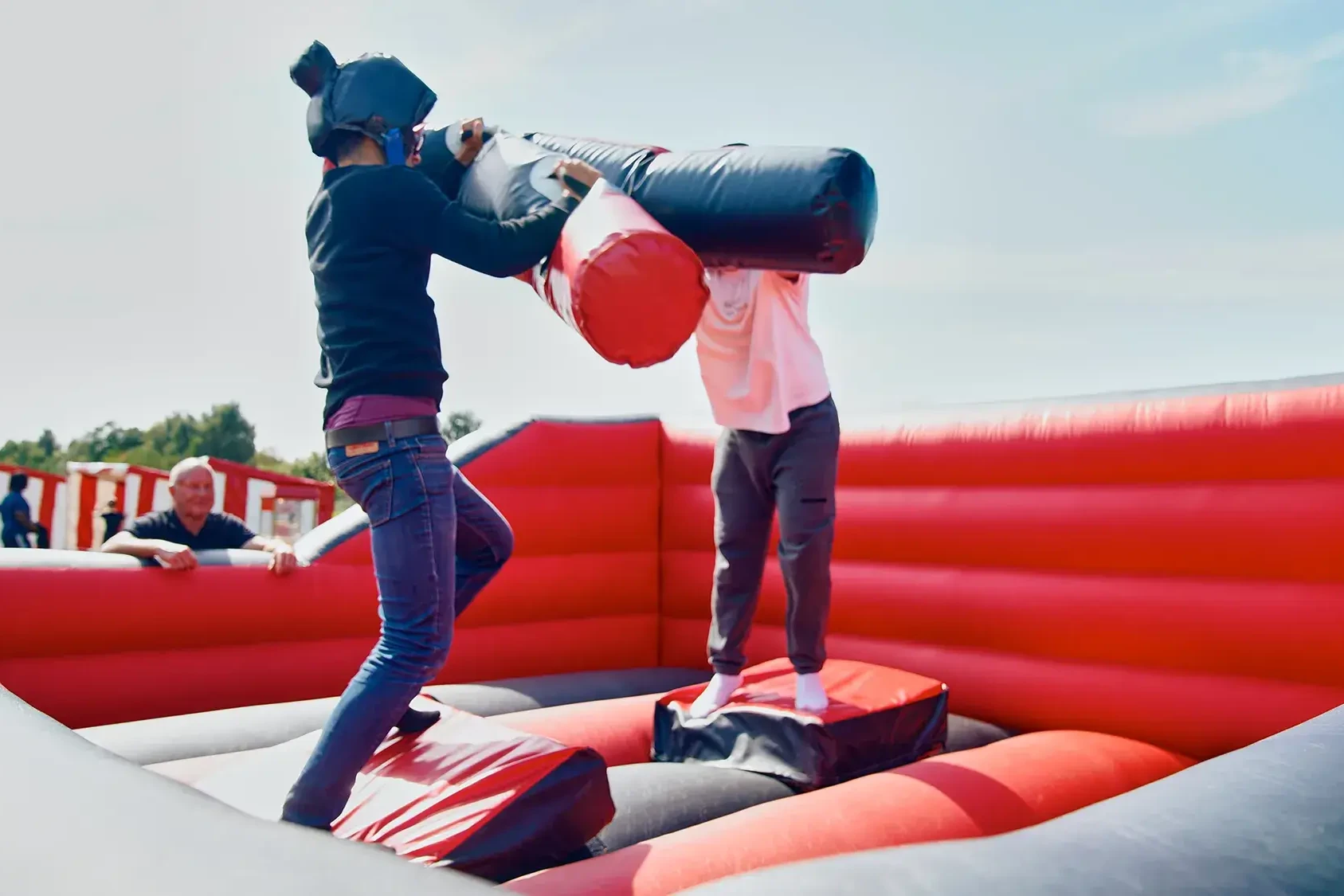 opponents fighting in inflatable team building activity with pugil sticks